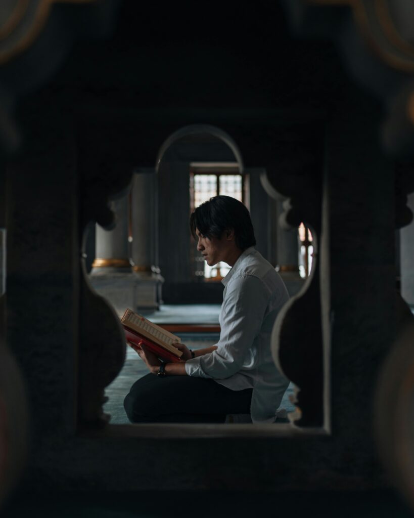 pexels-photo-16197216-16197216 A man in a mosque reads the Quran in a peaceful setting.
